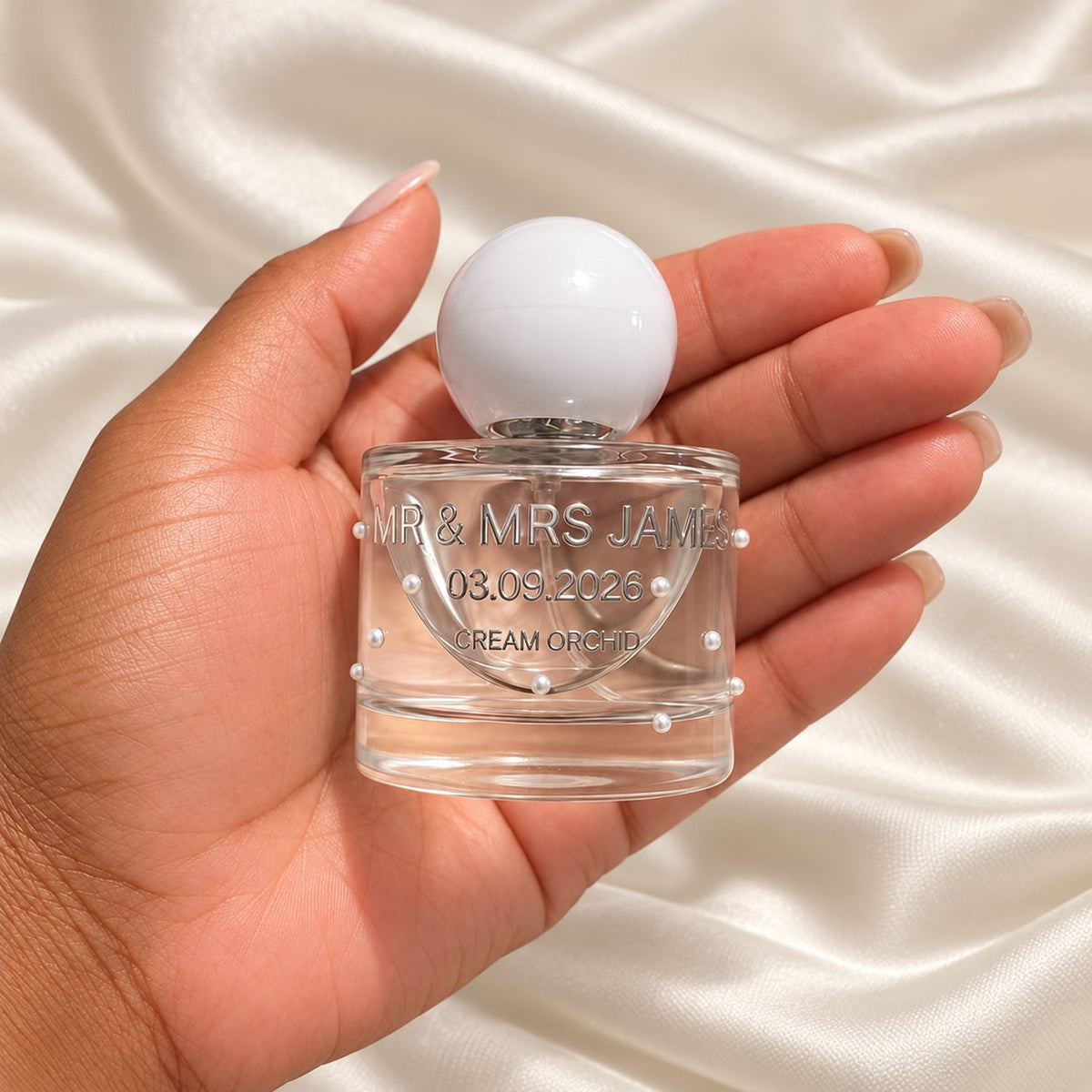 30ml Round Perfume Wedding Favours held in a neatly manicured hand on ivory satin
