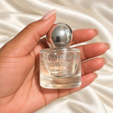 30ml Round Perfume Wedding Favours held in a neatly manicured hand on ivory satin