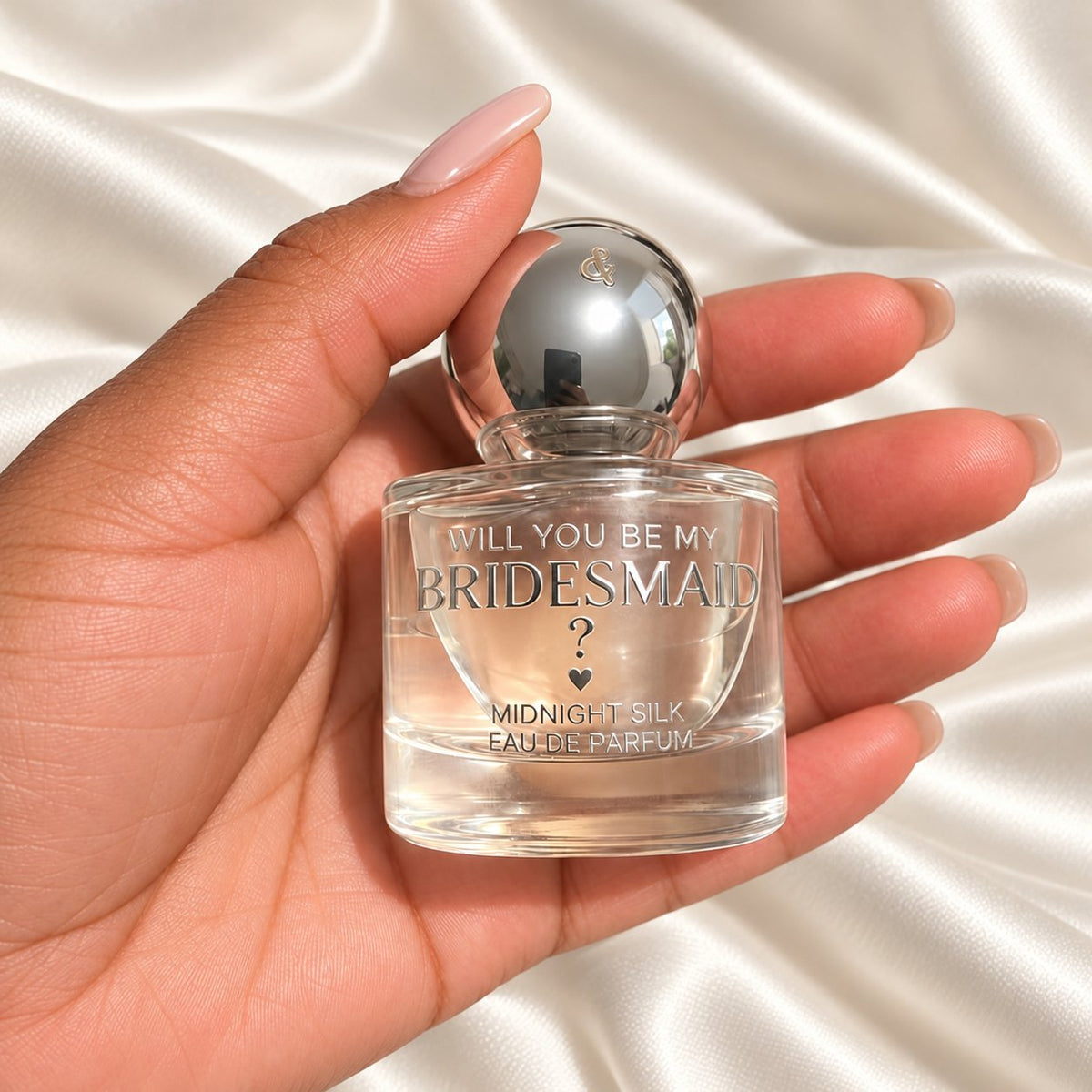Personalised Bridesmaid Proposal Perfume held in a neatly manicured hand on ivory satin