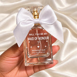 Personalised Maid of Honour Proposal Perfume held in a neatly manicured hand on ivory satin