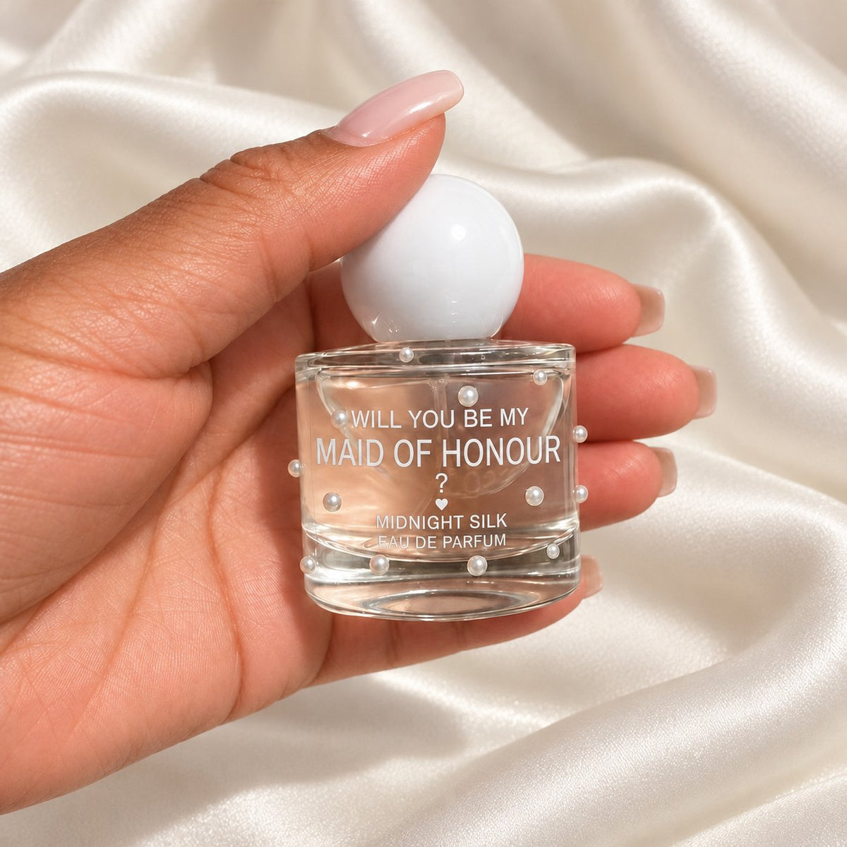 Personalised Maid of Honour Proposal Perfume held in a neatly manicured hand on ivory satin